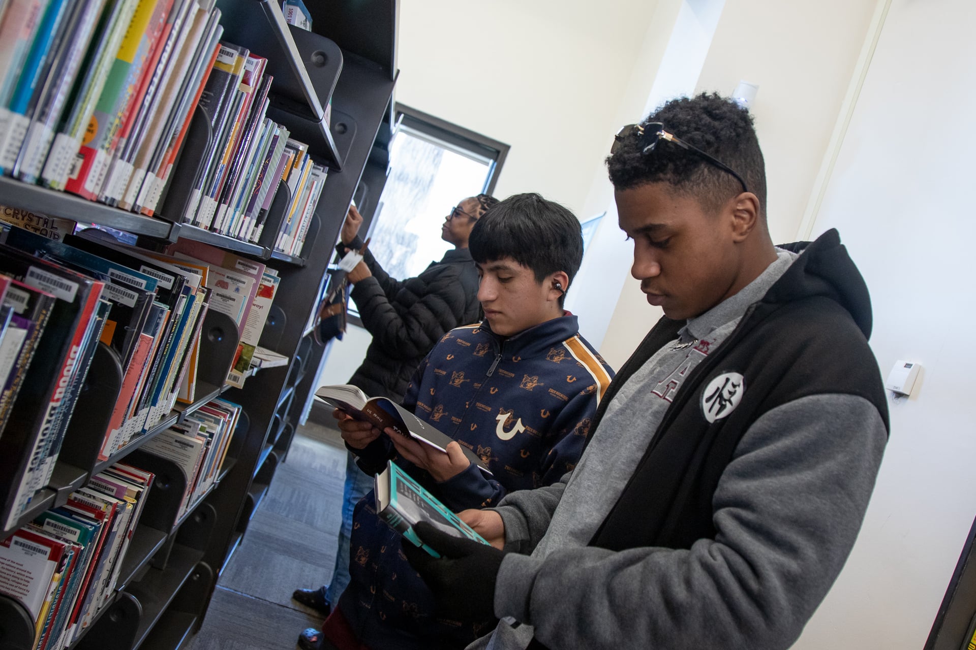 students looking in library books