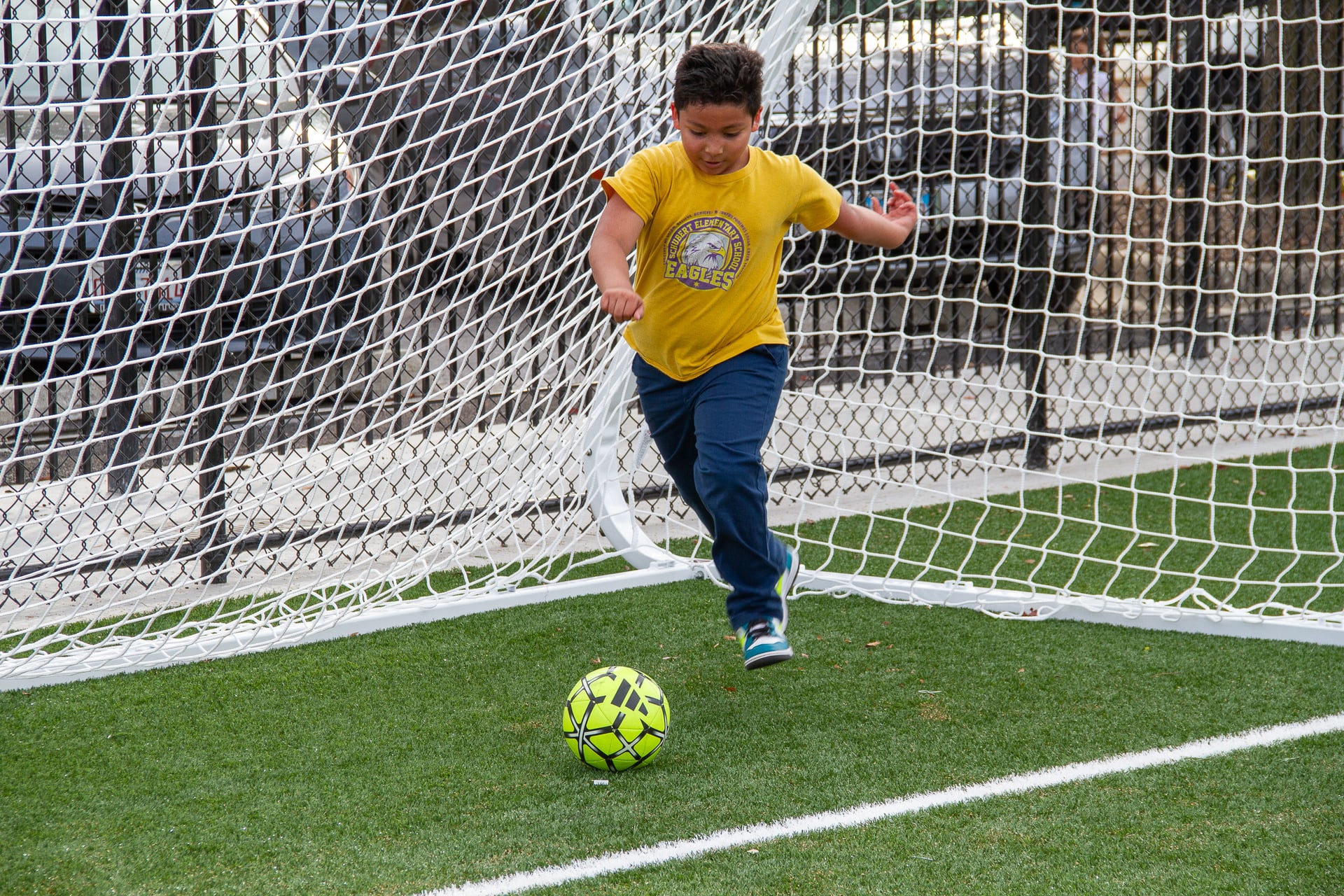 student kicking a soccer ball