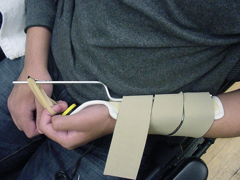 Student using a splint for accessing a switch.