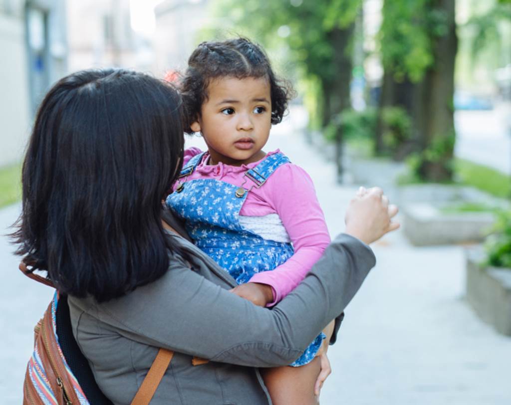 Mother holding young three-year-old daughter