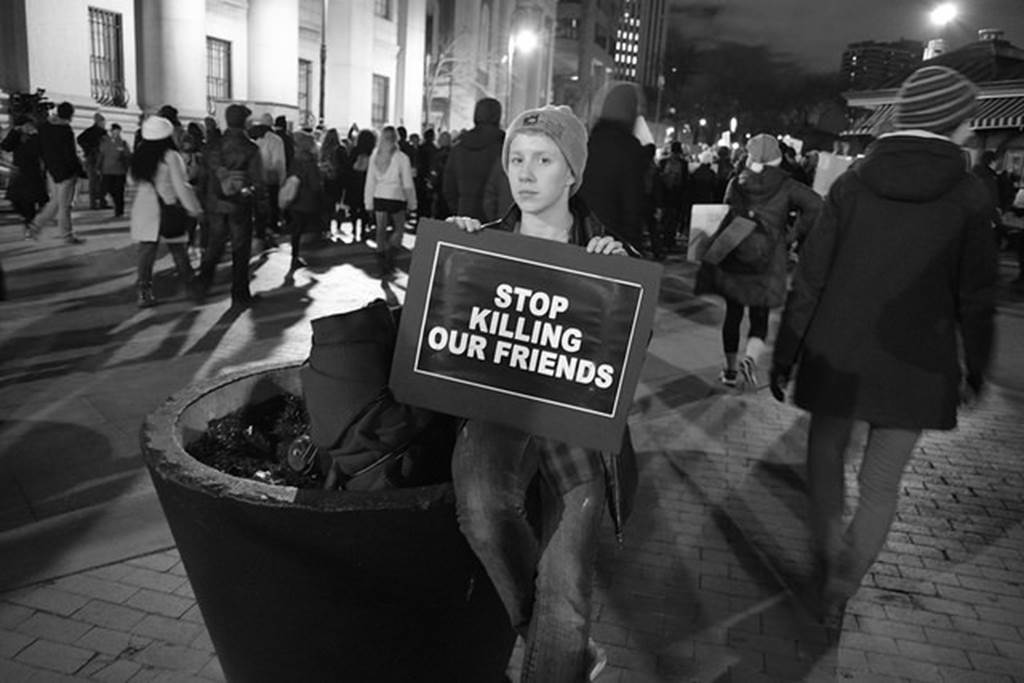 student holding sign reading stop killing our friends