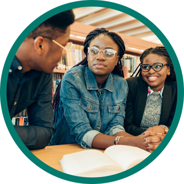 Three students talking in a library