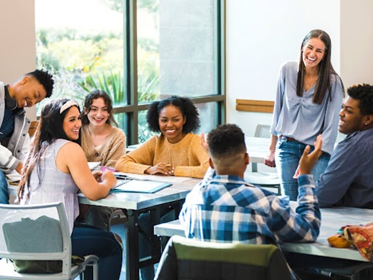 image of teacher laughing with High School Students