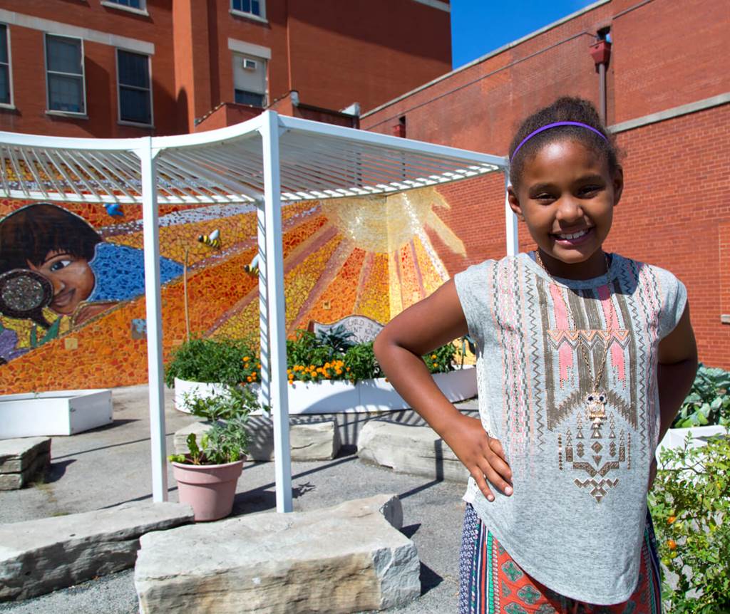 girl standing in front of a mural