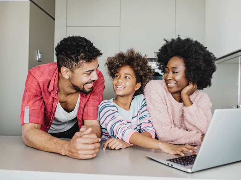 parents with child in front of a laptop