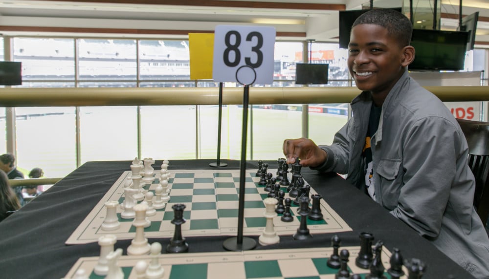 Student sitting in front of chess board