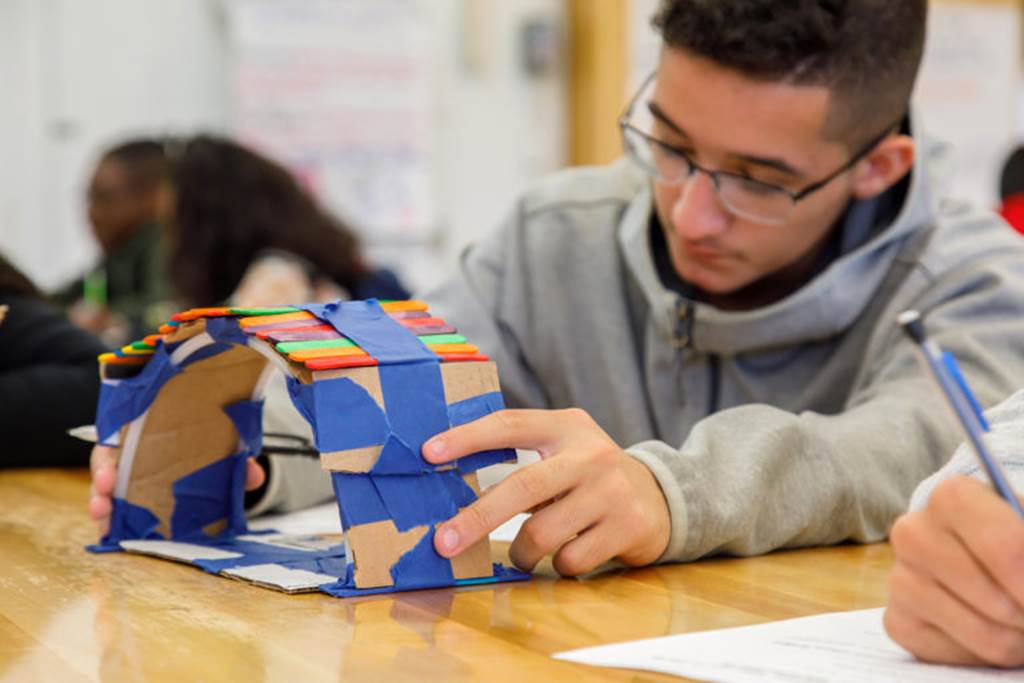 Student holding up a cardboard structure