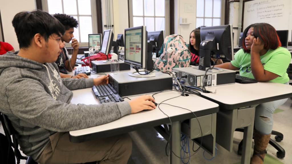 Students sit at computers