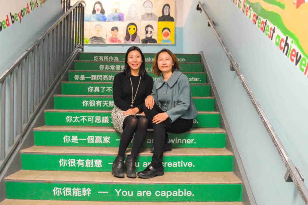 Two women sit on steps