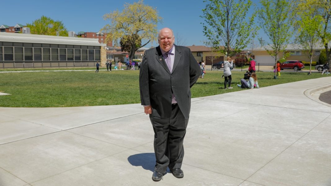 Principal Lucas standing in front of the school