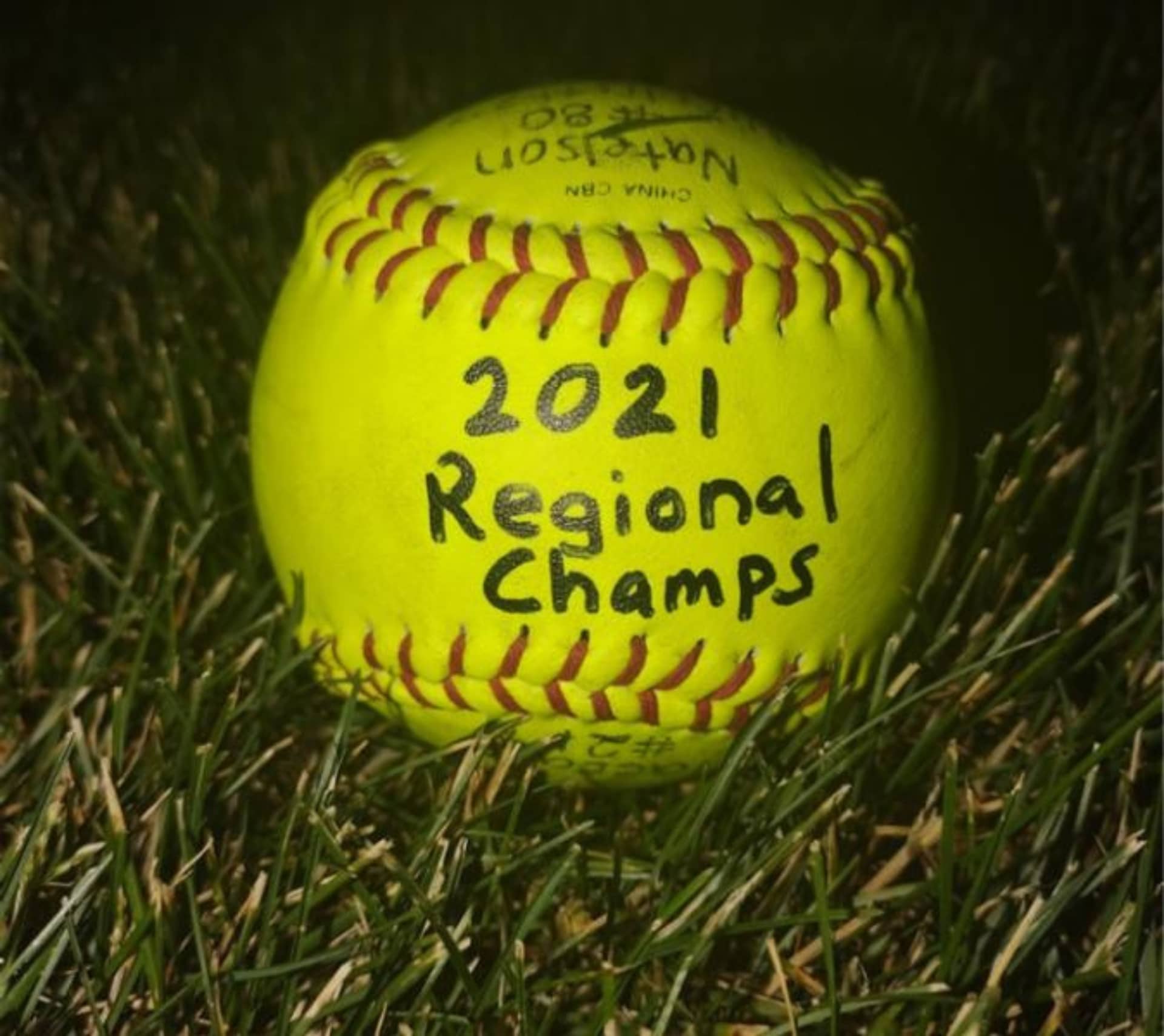 A softball with "2020 Regional Champs" written on it